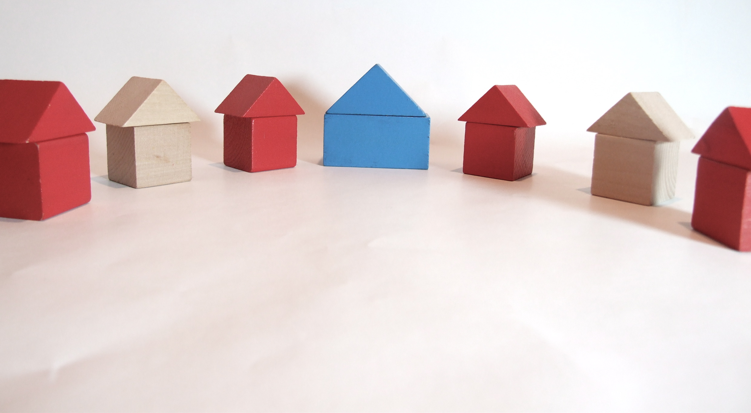 3 wood toy houses on a white background