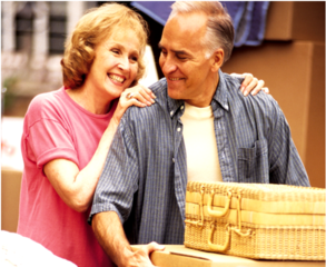Senior man and woman moving boxes while smiling at each other lovingly