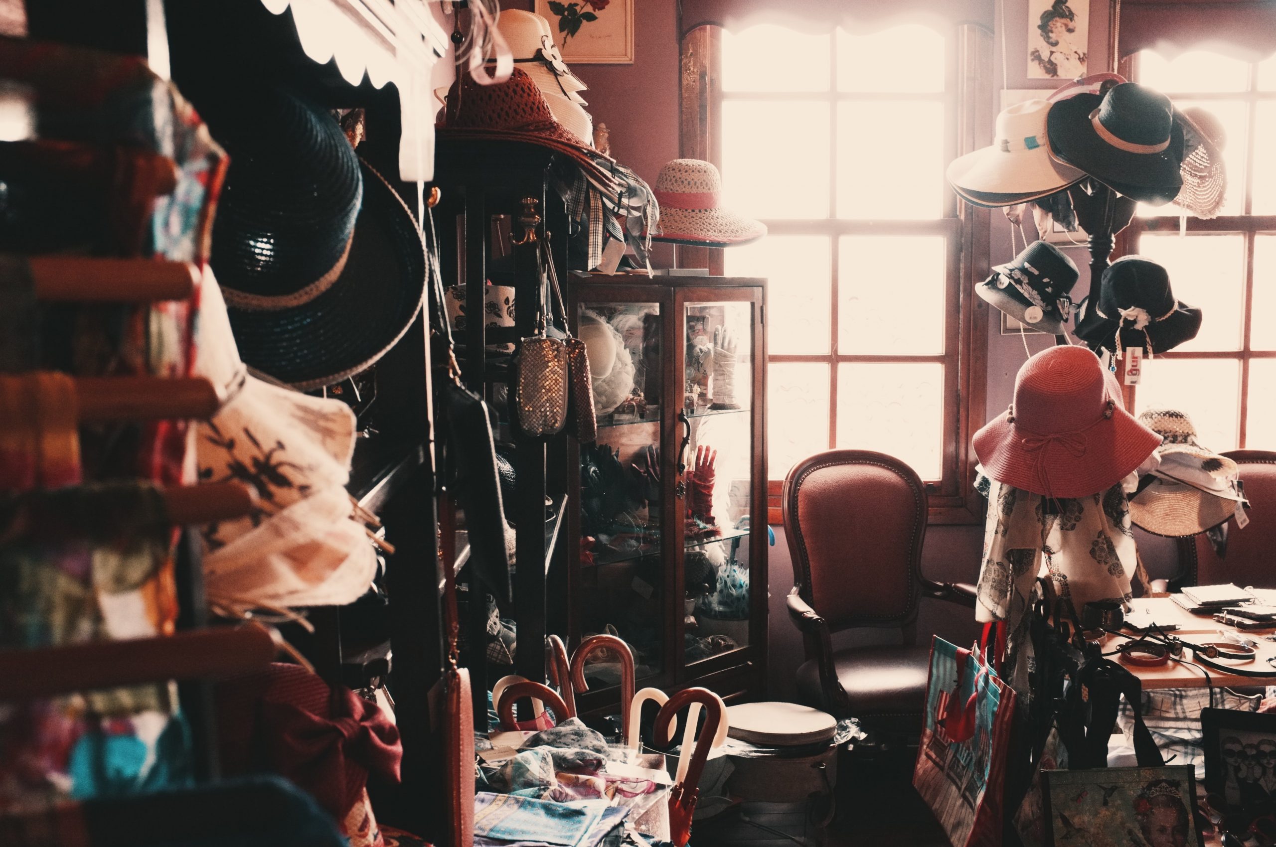 Room cluttered with vintage items such as hats and umbrellas