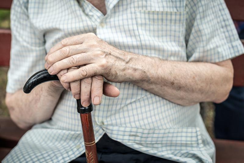 Photo of a senior man's hands holding a cane