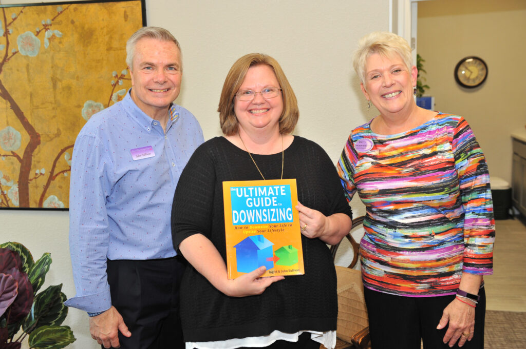 Ingrid Sullivan, John Sullivan and Debbie Ford show off a copy of The Ultimate Guide to Downsizing