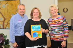 The Senior Downsizing Experts Team shows off their book, The Ultimate Guide to Downsizing